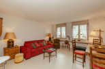 This charming living space features a cozy red sofa, perfect for relaxing.