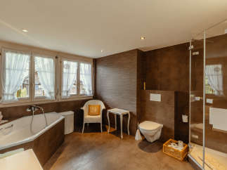 This luxurious bathroom features a modern design with a touch of rustic charm.