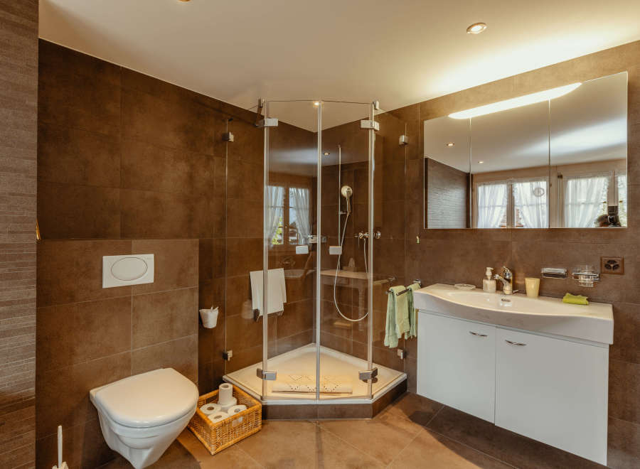 This modern bathroom features a sleek glass shower enclosure and a stylish white vanity.