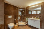 This modern bathroom features a sleek glass shower enclosure and a stylish white vanity.