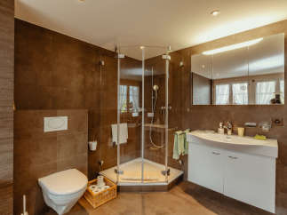 This modern bathroom features a sleek glass shower enclosure and a stylish white vanity.