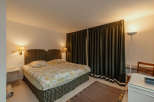 This cozy bedroom features a comfortable bed with floral bedding and a patterned headboard.