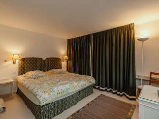 This cozy bedroom features a comfortable bed with floral bedding and a patterned headboard.