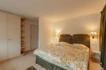 Cozy bedroom with a floral bedspread and patterned headboard.