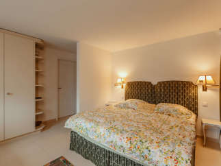 Cozy bedroom with a floral bedspread and patterned headboard.