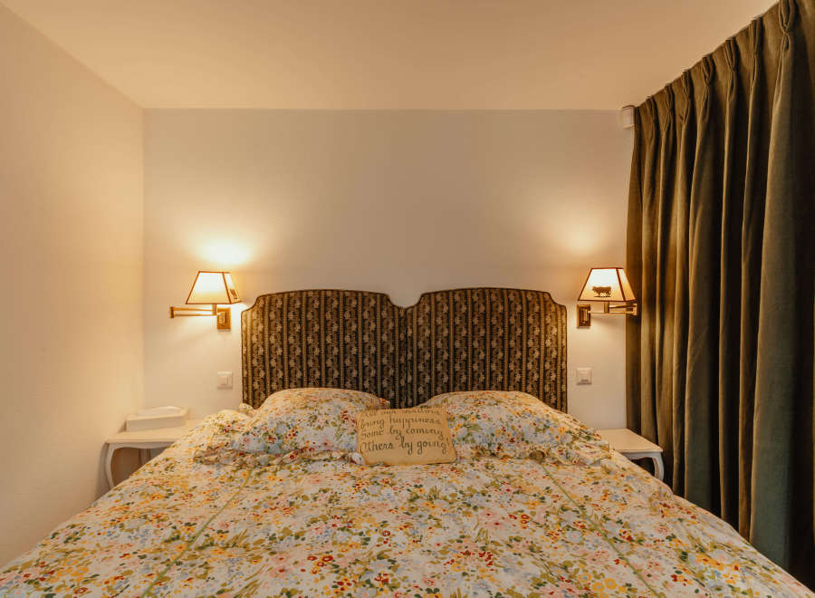 Cozy bedroom with a floral bedspread and a decorative headboard.