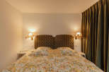 Cozy bedroom with a floral bedspread and a decorative headboard.