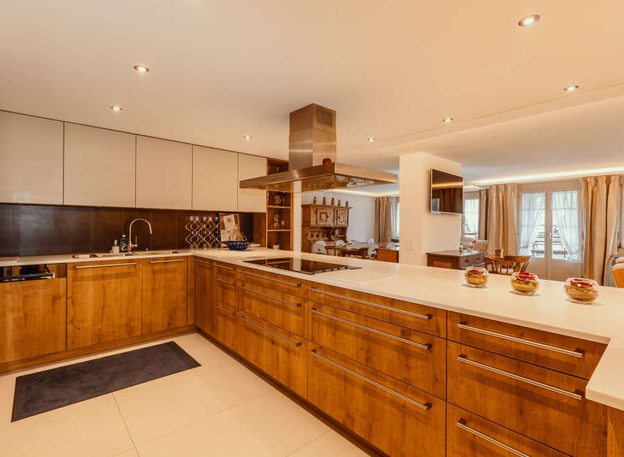 This stunning kitchen boasts a modern design with sleek wooden cabinetry and a spacious layout.