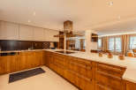This stunning kitchen boasts a modern design with sleek wooden cabinetry and a spacious layout.
