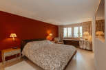 This cozy bedroom features a warm, inviting atmosphere with a rich red accent wall.