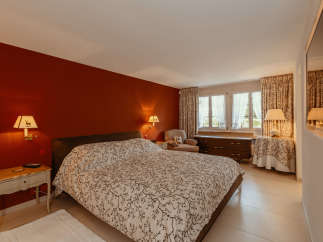 This cozy bedroom features a warm, inviting atmosphere with a rich red accent wall.