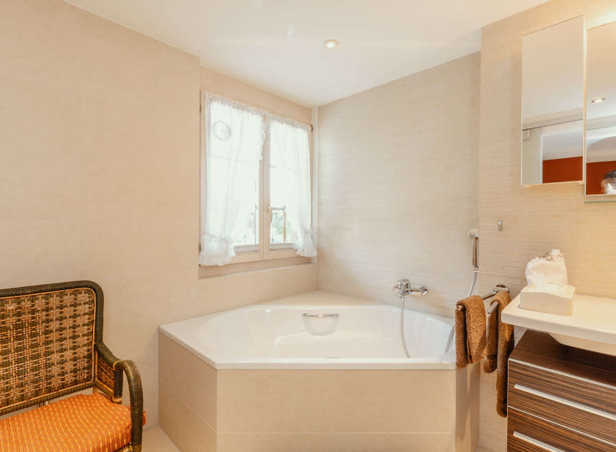 This beautiful bathroom features a luxurious corner bathtub, perfect for relaxing after a long day.