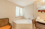 This beautiful bathroom features a luxurious corner bathtub, perfect for relaxing after a long day.