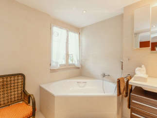 This beautiful bathroom features a luxurious corner bathtub, perfect for relaxing after a long day.