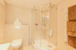 This modern bathroom features a sleek glass shower enclosure, offering a spacious and inviting bathing experience.