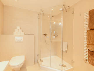 This modern bathroom features a sleek glass shower enclosure, offering a spacious and inviting bathing experience.