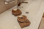 Indulge in the luxurious comfort of this bathroom, featuring elegant towels and a pristine sink.
