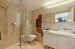 This modern bathroom features a sleek glass shower, a stylish vanity with ample storage, and a comfortable toilet.