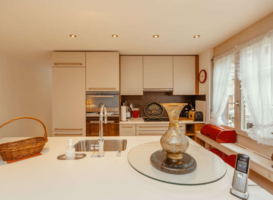 This bright and airy kitchen features modern cabinetry and a sleek countertop, perfect for culinary enthusiasts.