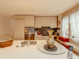 This bright and airy kitchen features modern cabinetry and a sleek countertop, perfect for culinary enthusiasts.