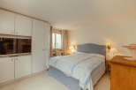 This cozy bedroom features a comfortable bed with a stylish headboard and elegant bedding.