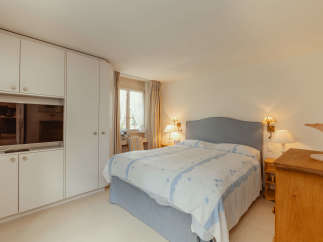 This cozy bedroom features a comfortable bed with a stylish headboard and elegant bedding.