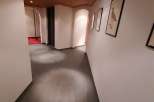 Explore the elegant hallway featuring a warm wooden ceiling and sleek, dark flooring.