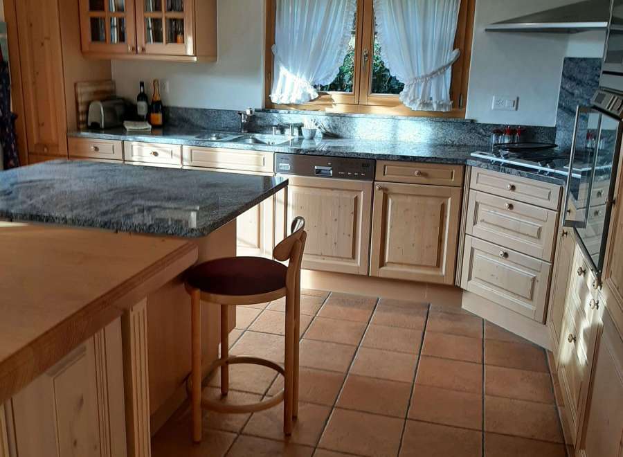 This charming kitchen boasts a warm and inviting atmosphere with its natural wood cabinetry and terracotta tile flooring.