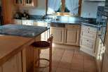 This charming kitchen boasts a warm and inviting atmosphere with its natural wood cabinetry and terracotta tile flooring.