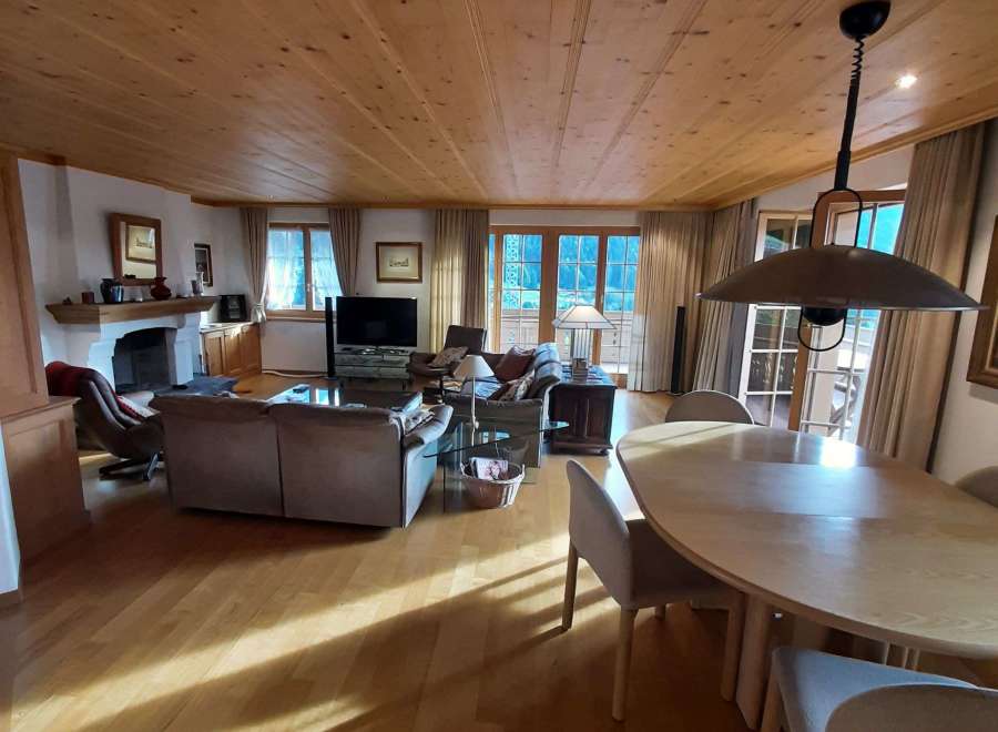Experience the warmth of this inviting living space, featuring a stunning wooden ceiling and a cozy fireplace.