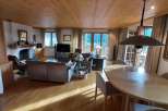 Experience the warmth of this inviting living space, featuring a stunning wooden ceiling and a cozy fireplace.