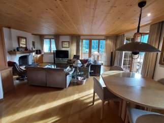 Experience the warmth of this inviting living space, featuring a stunning wooden ceiling and a cozy fireplace.