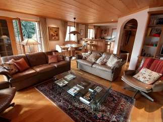 Step into a cozy living space with a warm wooden ceiling and inviting leather sofas.