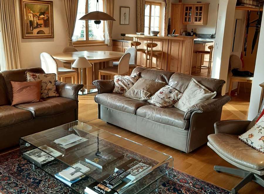 This stunning living room boasts a warm and inviting atmosphere with its wooden ceiling and elegant furnishings.