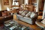 This stunning living room boasts a warm and inviting atmosphere with its wooden ceiling and elegant furnishings.
