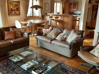 This stunning living room boasts a warm and inviting atmosphere with its wooden ceiling and elegant furnishings.
