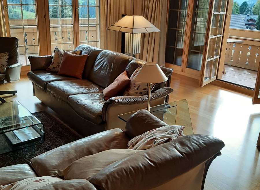This stunning living room boasts a cozy atmosphere with its leather sofas and warm wooden accents.