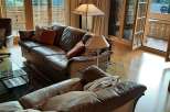This stunning living room boasts a cozy atmosphere with its leather sofas and warm wooden accents.