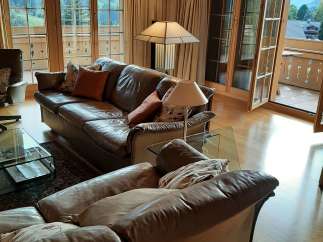 This stunning living room boasts a cozy atmosphere with its leather sofas and warm wooden accents.