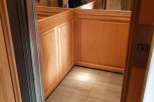 Step into luxury with this stunning elevator, featuring exquisite wood paneling and a sleek, modern design.