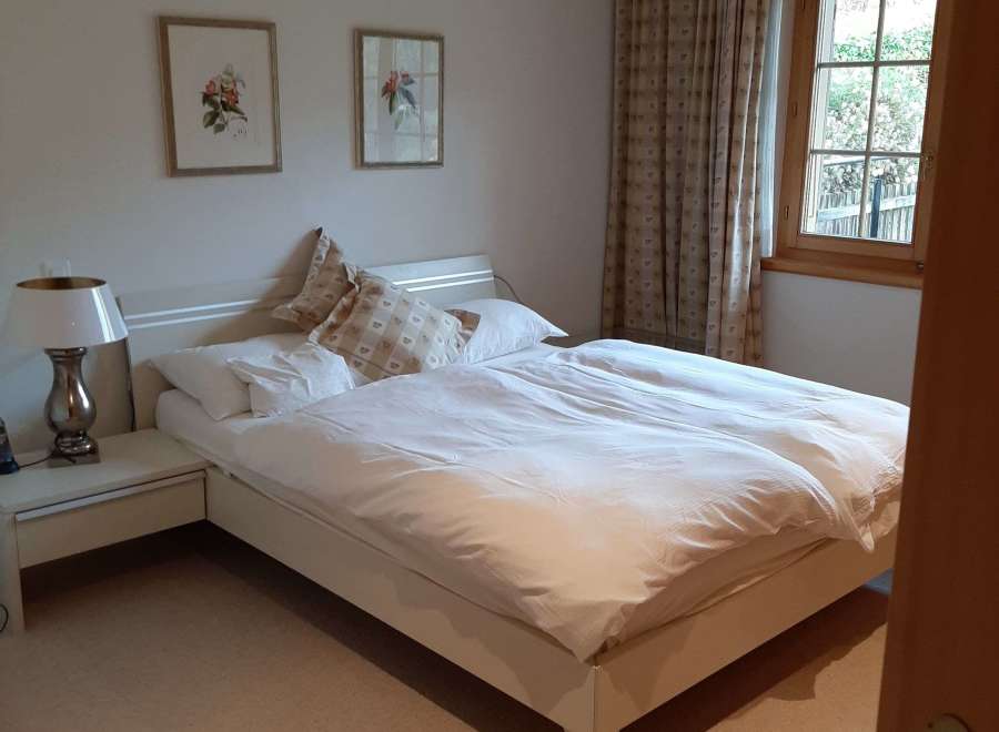 This cozy bedroom features a comfortable bed with fresh white linens, perfect for a relaxing stay.
