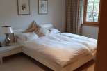 This cozy bedroom features a comfortable bed with fresh white linens, perfect for a relaxing stay.