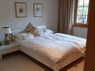This cozy bedroom features a comfortable bed with fresh white linens, perfect for a relaxing stay.