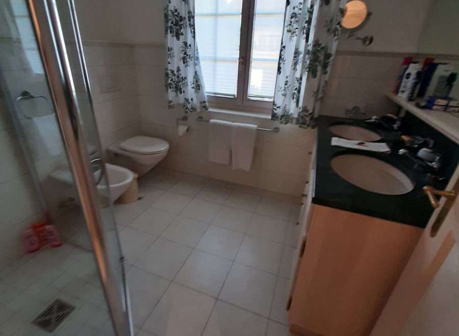 This bathroom features a classic design with tiled floors and walls, creating a clean and inviting space.