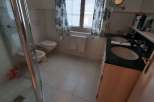 This bathroom features a classic design with tiled floors and walls, creating a clean and inviting space.