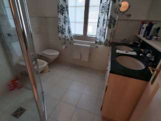 This bathroom features a classic design with tiled floors and walls, creating a clean and inviting space.