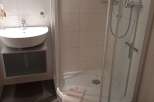 This bathroom features a modern design with a sleek, white sink and a spacious shower.