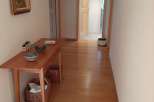 This inviting hallway showcases beautiful hardwood floors and a warm, welcoming atmosphere.