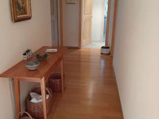 This inviting hallway showcases beautiful hardwood floors and a warm, welcoming atmosphere.