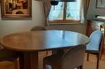This charming dining area features a round wooden table, perfect for intimate gatherings.